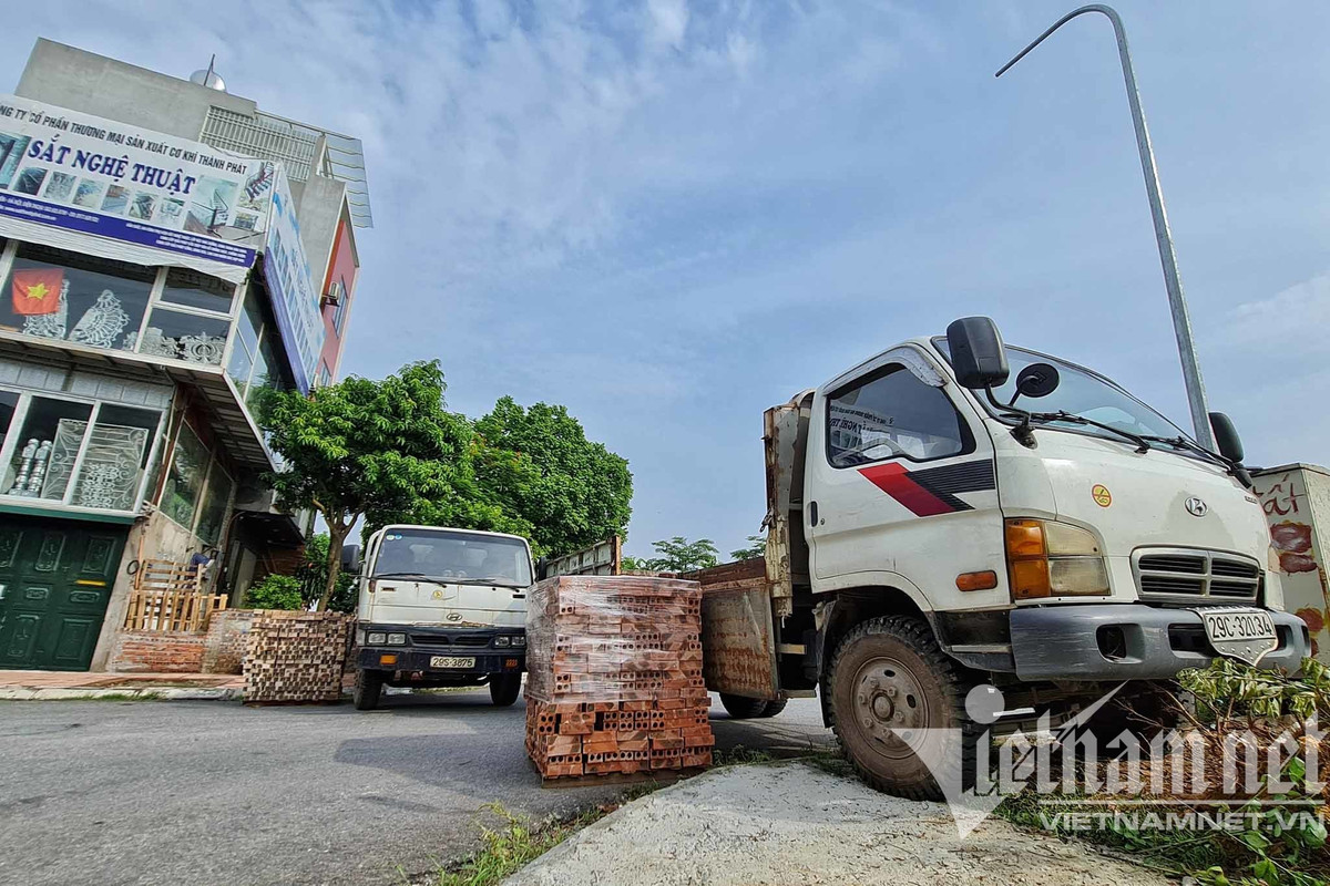 Tại khu vực phía đê, giáp ranh phường, lực lượng chức năng đặt các đống gạch xếp cạnh nhau và treo biển "các phương tiện không đi lối này". (Ảnh: Vietnamnet) 