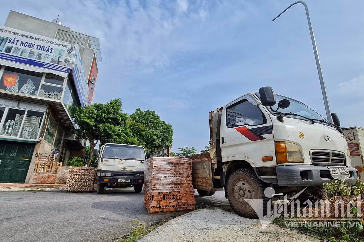 Tại khu vực phía đê, giáp ranh phường, lực lượng chức năng đặt các đống gạch xếp cạnh nhau và treo biển "các phương tiện không đi lối này". (Ảnh: Vietnamnet) 