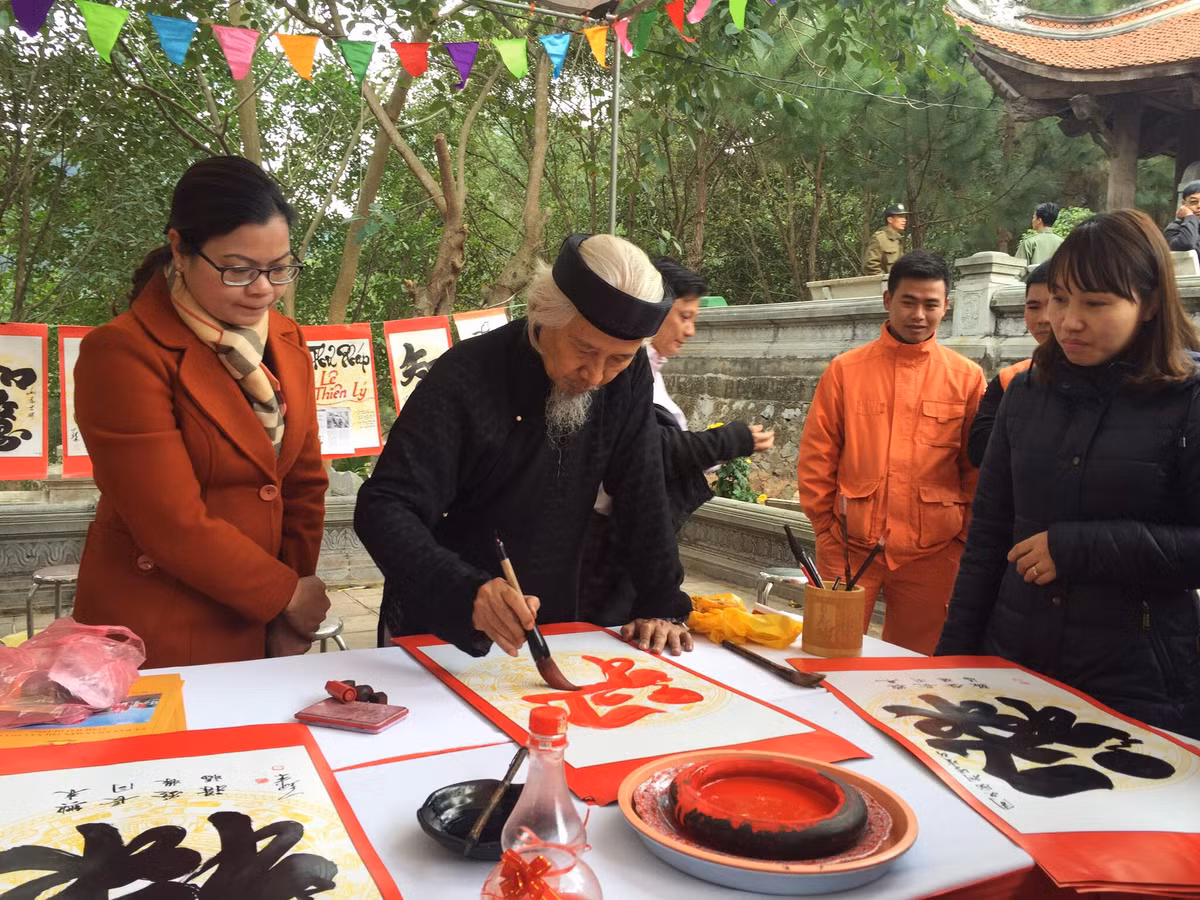 Nhà thư pháp Lê Thiên Lý cho chữ người dân.