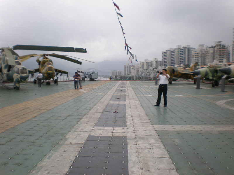 Nhìn chung, người ta chỉ sửa lại ở bên trong nội thất phục vụ các hoạt động giải trí, bên ngoài con tàu không được sơn sửa gì nhiều khiến nó khá cũ. Mặt boong phóng máy bay bố trí hỗn độn các loại phi cơ cũ của Liên Xô, không hẳn chỉ tiêm kích Yak-38 hay trực thăng Ka-27. Ảnh: Wikipedia