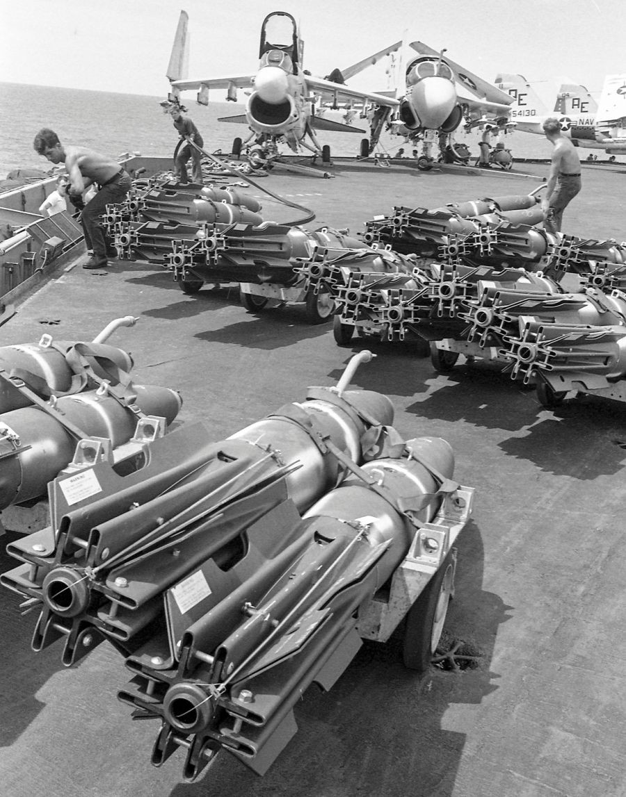 Mục tiêu chủ yếu của chiến dịch "Rồng biển" là đánh chặn, phá hủy các tàu vận tải của miền Bắc Việt Nam gồm những xà lan tự hành cỡ lớn tới thuyền buồm cỡ nhỏ. Ảnh: Hàng dài các quả bom xếp trên boong tàu sân bay USS America chuẩn bị nạp lên các máy bay cường kích A-7A Corsair II và A-6A Intruder chuẩn bị cho nhiệm vụ không kích mục tiêu ở Bắc Đồng Hới, miền Bắc Việt Nam trong khuôn khổ “Rồng biển”. Ảnh: Stars and Stripes