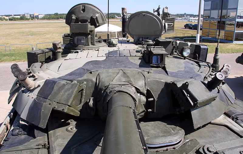 Cụ thể, giáp bảo vệ, ngoài giáp composite, T-80U cũng được trang bị giáp phản ứng nổ Kontakt-5. Dòng xe tăng này hoàn toàn có thể tích hợp hệ thống phòng vệ chủ động Shtora-1 tùy theo yêu cầu của khách hàng. Nguồn ảnh: Wikipedia