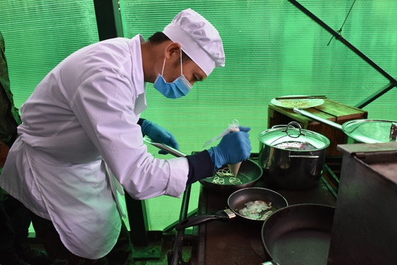 Tổ nấu ăn phải tính toán lượng thực phẩm để đủ nấu cho 20 suất ăn. Về cảm quan đòi hỏi món ăn phải có sự đồng nhất về hình dạng, màu sắc và mùi vị. Trong quá trình thi, các thành viên phải tuân thủ những quy định nghiêm ngặt như: Trước khi đeo găng tay phải rửa tay, đang đi găng tay mà ra rửa trang bị, dụng cụ vào chế biến món ăn thì phải thay găng khác, thịt thái phải đúng thớ, khi thức ăn chín phải lấy muôi múc, không được cầm cả xoong đổ ra… Nguồn ảnh: Báo QĐND