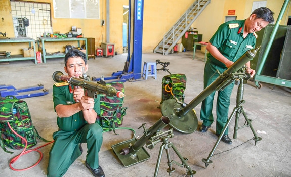 Trung úy Đăng cho biết: "Chúng tôi tận dụng kim loại có sẵn để "nhân bản" giống như súng cối 82mm thật nhưng trọng lượng chỉ khoảng 36kg (bằng hơn nửa trọng lượng súng thật), chỉ khác là có thêm bộ phận chứa hơi (có van nạp, van xả) đấu vào bình khí nén. Riêng quả đạn có trọng lượng 200g, thân làm bằng vỏ chai nước ngọt, đầu đạn gồm một hạt nổ, một kim hoả, thuốc đạn, xăng, bông gòn và đuôi bằng nhựa cứng… Nguồn ảnh: báo QĐND