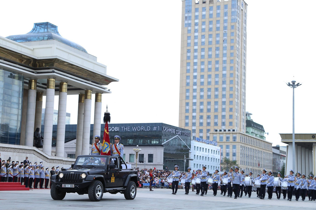 Xe Jeep chở quân kỳ dẫn đầu đội quân nhạc tiến vào quảng trường ở Ulan-Bator. Nguồn ảnh: dambiev
