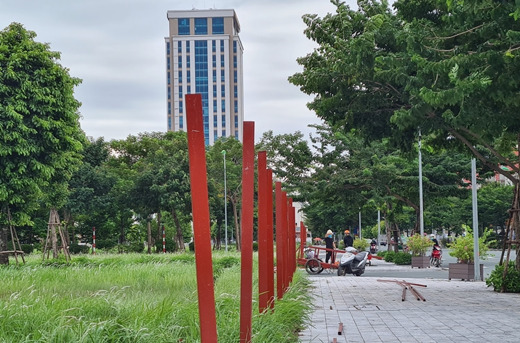 Công nhân dựng hàng rào để chuẩn bị quây nốt các khu đất chưa xây dựng.