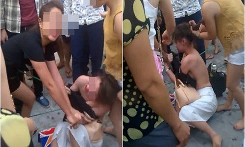 Bốn người phụ nữ túm tóc, lột áo, đánh đập một cô gái giữa phố vì ghen tuông - Ảnh chụp lại từ clip.