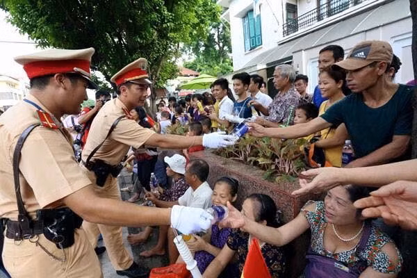 Hình ảnh các chiến sĩ cảnh sát giao thông phát chai nước miễn phí cho nhân dân được rất nhiều người chia sẻ trên mạng xã hội .