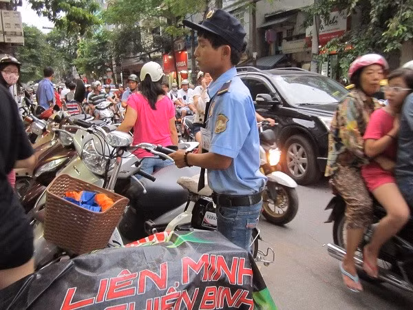 Những chú bảo vệ miệt mài hướng dẫn khách và sắp xếp xe cho khách an tâm mua bánh.