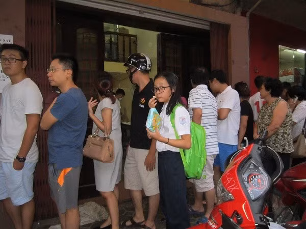 Một khách hàng trong lúc đón con đi học về hai bố con cũng tranh thủ vào xếp hàng mua bánh trung thu.
