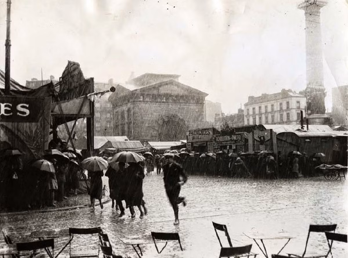 Place de la Nation, Paris, Pháp trong một ngày mưa tầm tã. Người dân vội vã di chuyển trên đường đến nơi trú mưa hoặc về nhà.