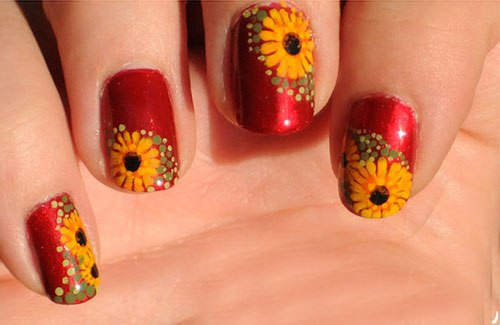 Mẫu nail hoa cúc vàng nổi bật trên nền đỏ rực tỏa sáng những ngày đầu năm.