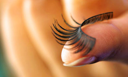 Dùng kẹp kẹp mi. Kẹp từ gốc nhay dần ra ngoài. Chuốt mascara dưỡng làm dày và dài cho mi trên và dưới. Gắn mi giả phần đuôi mắt rồi chuốt mascara. Dặm chân mày với màu cam.