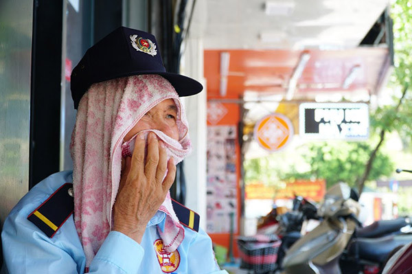 Vì thời tiết quá nóng bức người bảo vệ này đã dùng khăn choàng lên đầu cho dễ chịu.