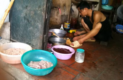 Hình ảnh tại một quán phở ở Hà Nội quán khiến những người chứng kiến cảnh này không khỏi 'rùng mình'. Người bán hàng bày lòng ra chậu mà không che đậy để ruồi bu. Không những thế, gà còn được làm dưới nền gạch gần cống nước.