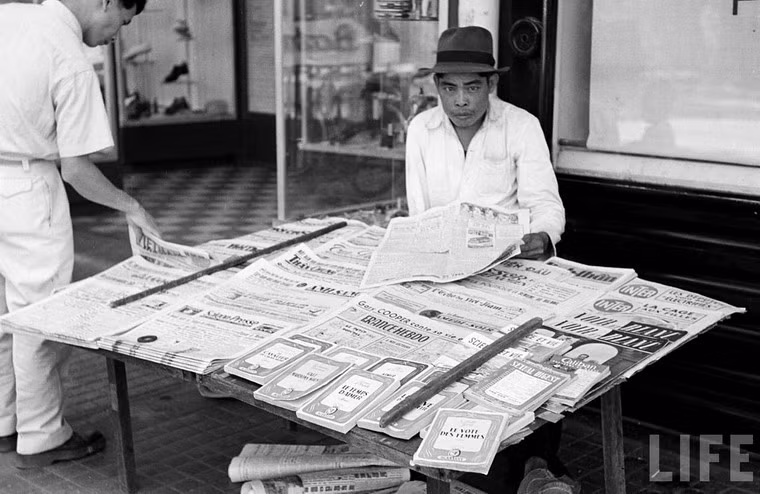 Báo tiếng Pháp và báo tiếng Việt nằm xen lẫn nhau trên sạp.