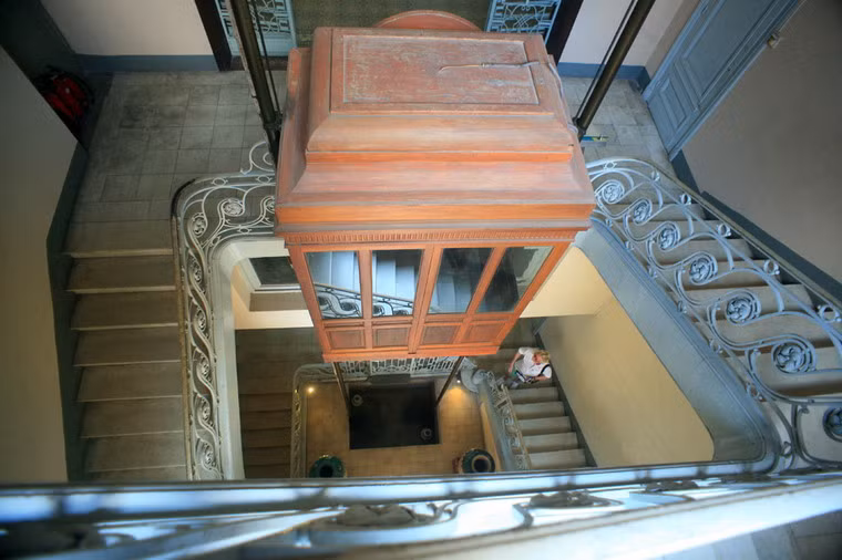 Buồng thang máy được làm bằng gỗ theo thiết kế cổ điển, với những ô cửa kính bao quanh bốn mặt.