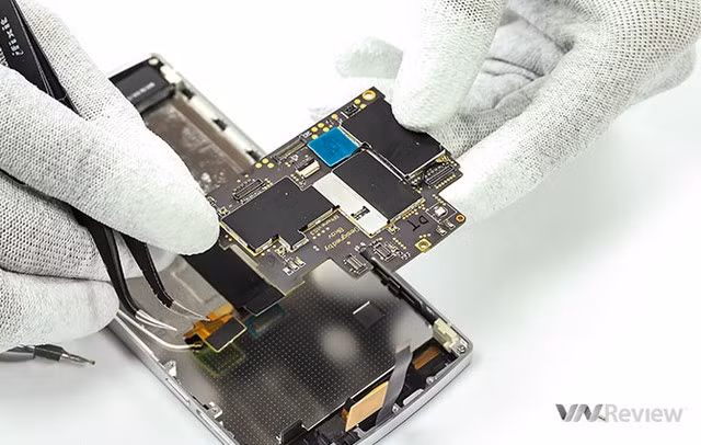 Sau khi tháo các con ốc và một số thành phần kết nối với mạch chính như khay SIM, cụm camera và cụm mô tơ rung cùng với giắc âm thanh, việc nhấc bo mạch ra khỏi khung máy dễ dàng.
