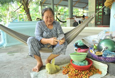 Bà Lê Thị Bảy - bà nội Ánh Viên - cặm cụi chẻ từng trái cau để phơi khô ăn với trầu.