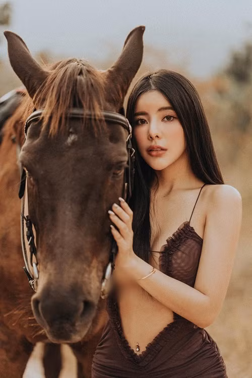 Khi đi cưỡi ngựa, cô nàng diện chiếc đầm cắt xẻ táo bạo để khoe trọn vóc dáng.