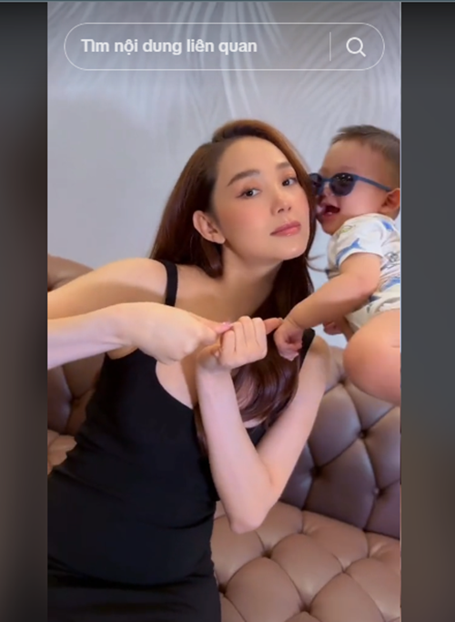 Bé Mỡ đeo kính đen, hôn má mẹ.