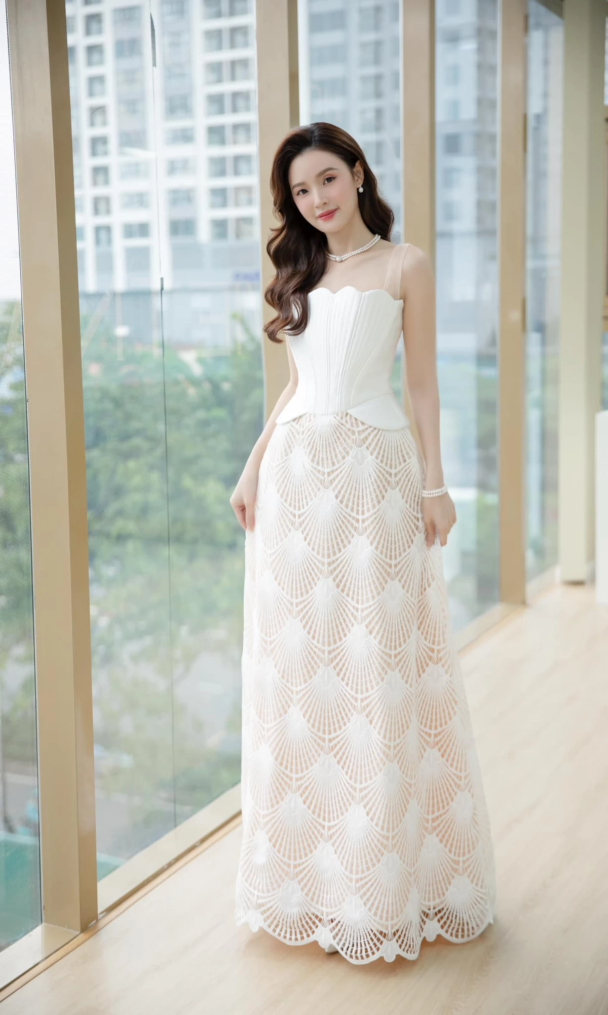 Tham dự buổi chấm thi, Midu chọn phong cách nhẹ nhàng, thanh tao với mẫu đầm dài không tay kiểu dáng corset kết hợp họa tiết cánh quạt. Phần áo định hình phom dáng giúp thân hình của bà xã thiếu gia Minh Đạt trở nên thon gọn, thanh mảnh hơn hẳn.