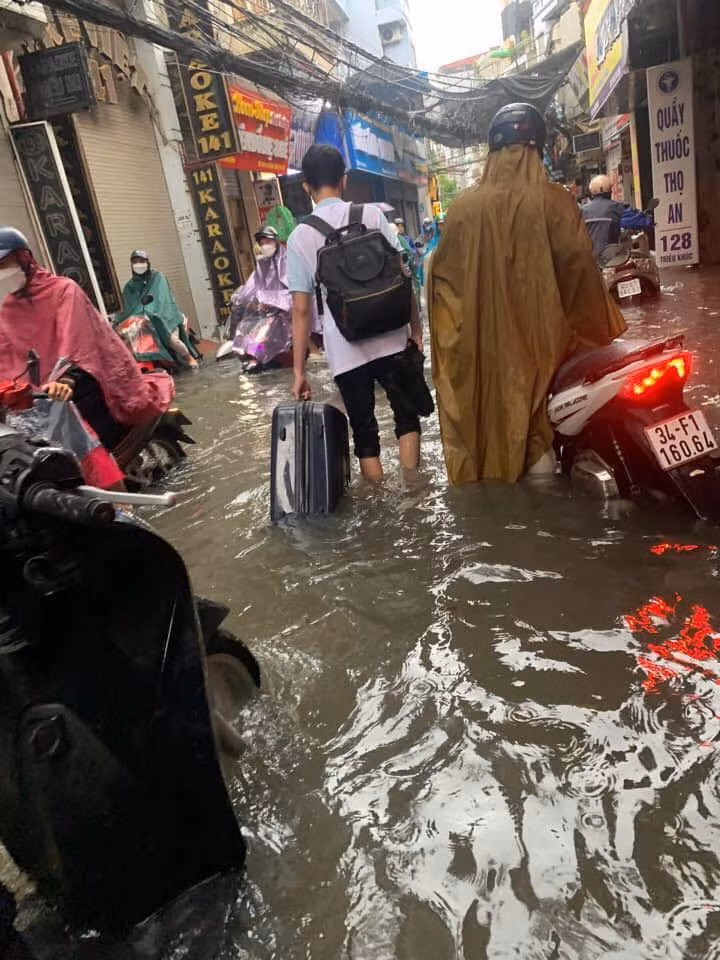 Mưa gió khiến người dân Hà Nội di chuyển khó khăn.