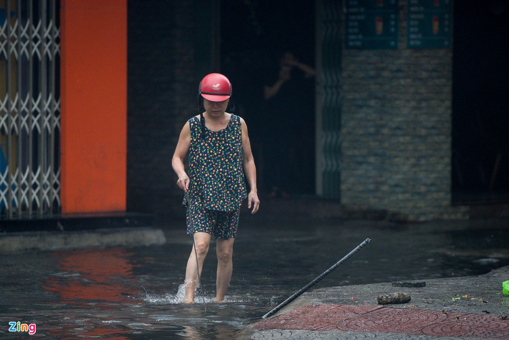 Bà Đoàn Thị Tho (phường Vĩnh Trung, Thanh Khê) cho biết tuyến phố Hàm Nghi ngập từ sáng sớm. Bà Tho cùng một số người dân dọn rác tại các nắp cống để nước rút nhanh hơn.