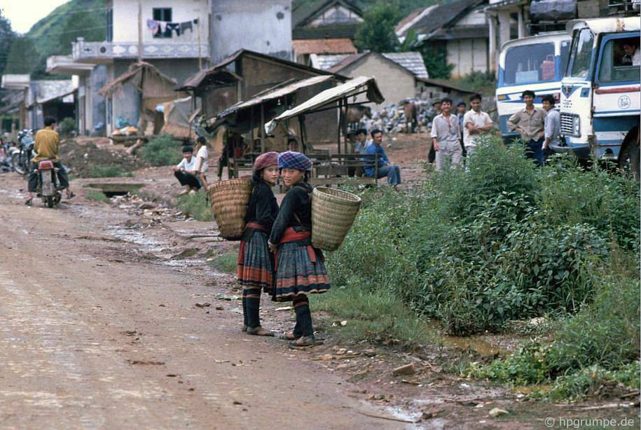 Thị trấn Sapa và các cô gái người dân tộc đeo gùi đứng ở bên đường.