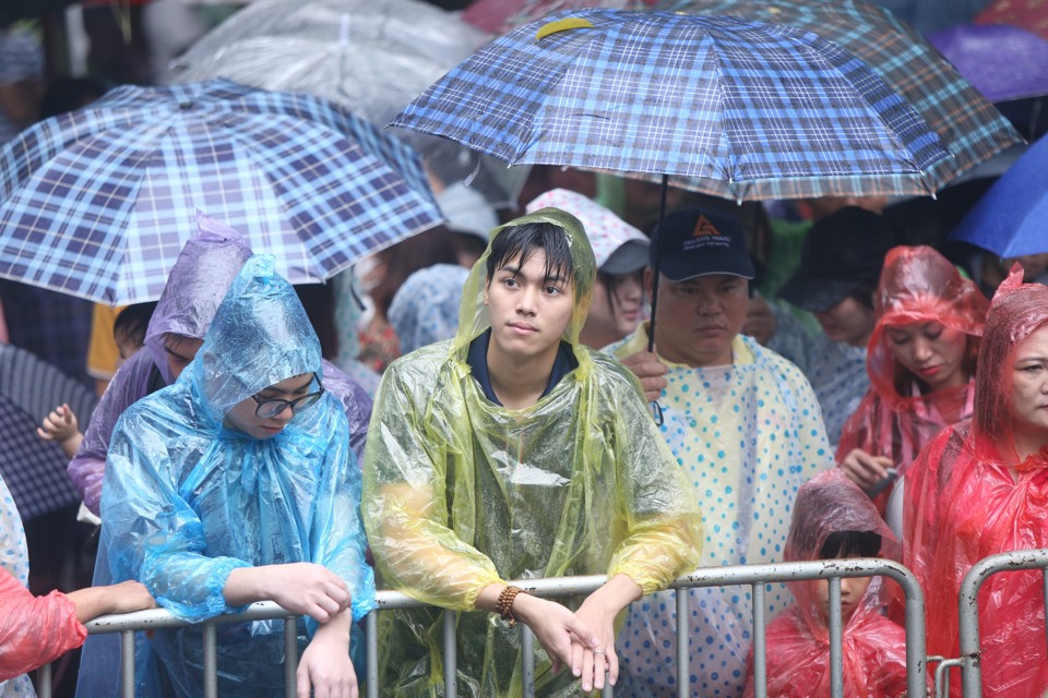Trời mưa từ sáng sớm, nhiều người phải mặc áo mưa, lấy ô che. Tuy nhiên, theo người dân và du khách đây là điều “may mắn”, "mưa rửa đền". (Ảnh Kinh tế đô thị)