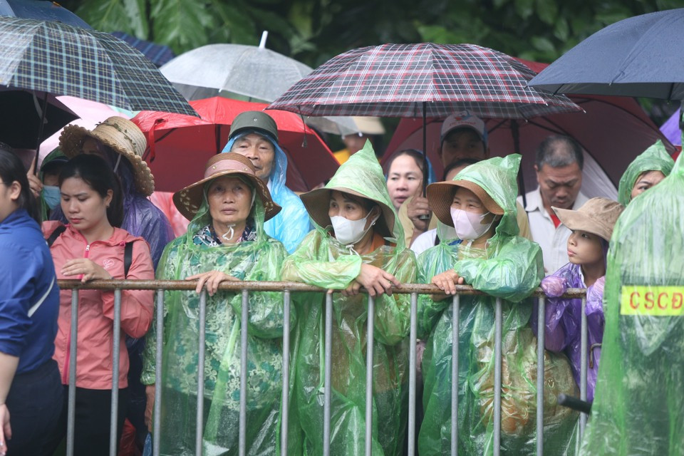 Khoảng gần 7 giờ, trời bắt đầu đổ mưa to. Thời điểm này cũng là lúc các lãnh đạo Đảng, Nhà nước thực hiện nghi thức dâng hương trên đền Thượng, người dân chưa được lên đền. Tuy vậy, hàng ngàn người dân đã đổ về khu vực sân trung tâm lễ hội, vị trí gần sân công quán để chờ được lên đền dâng hương. Nhiều người mang ô, mặc áo mưa mang theo lễ vật dâng cúng lên các bậc tiền nhân.(Ảnh Kinh tế đô thị)