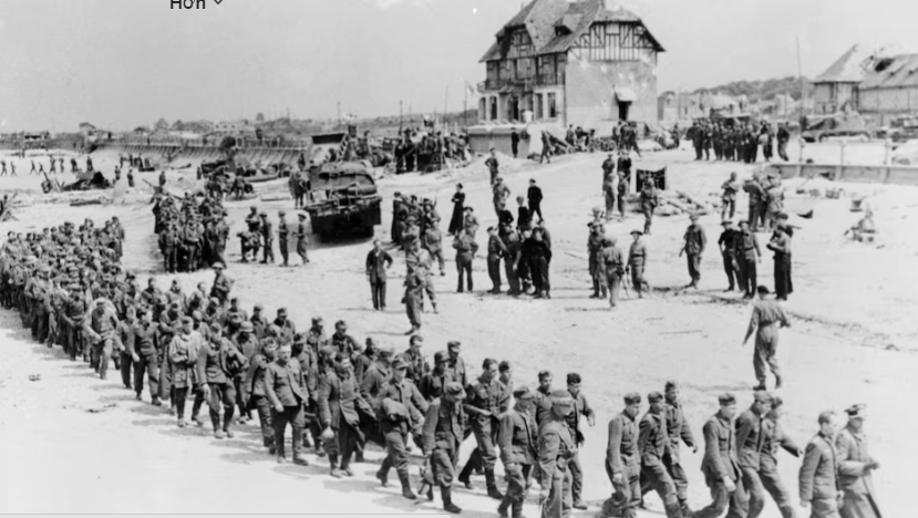 Các tù binh Đức bị áp giải lên một con tàu đưa họ sang Anh, sau khi họ bị quân đội Canada bắt giữ tại Bernieres Sur Mer, Pháp, ngày 6/6/1944.