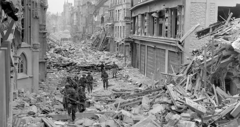 Binh sĩ Canada tuần tra dọc theo con đường Rue Saint-Pierre đổ nát sau khi quân Đức bị đánh bật khỏi Caen, tháng 7 năm 1944.