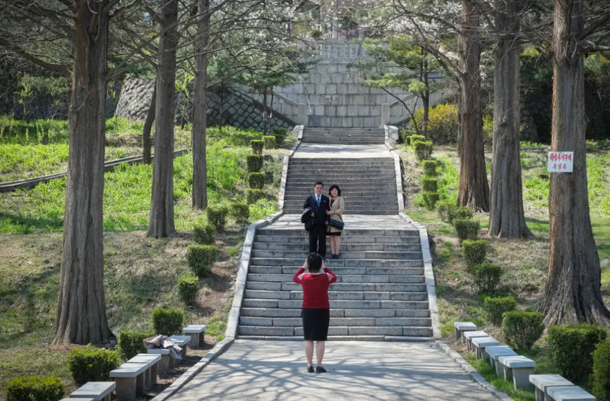 Người phụ nữ chụp ảnh cho một cặp đôi ở công viên Moran.