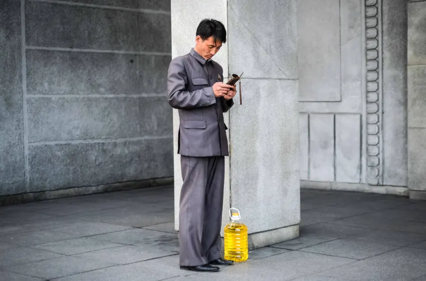 Một người đàn ông đang kiểm tra điện thoại trước khi lên tàu điện ngầm.