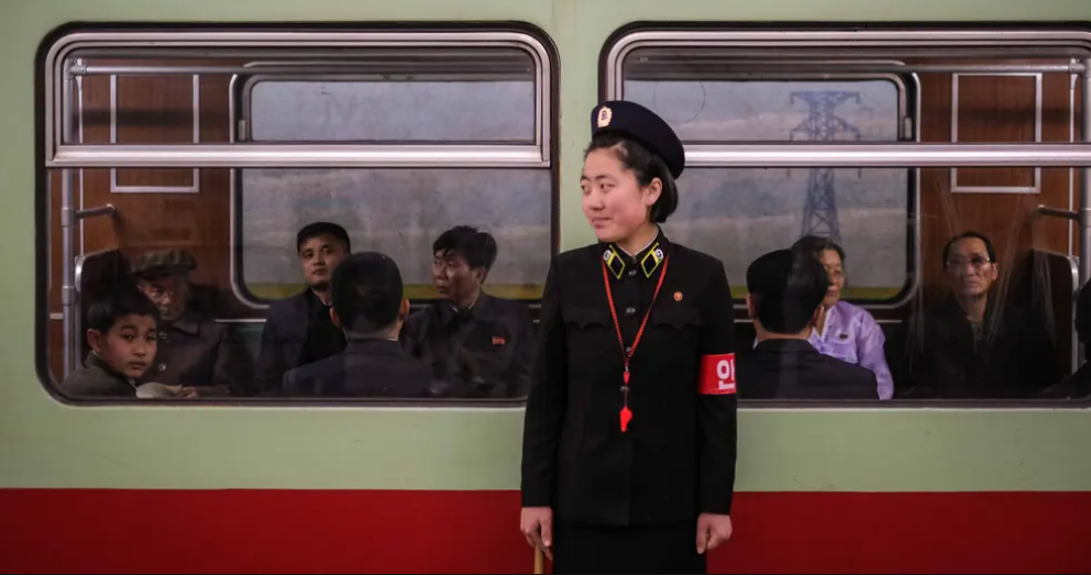 Nữ nhân viên bảo vệ đang đợi hành khách lên tàu điện ngầm.