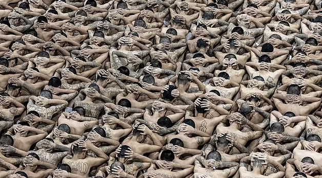 Những hình ảnh bên trong cho thấy, họ phải ngồi thành hàng, tay đặt phía sau cổ và cúi đầu xuống trong khi chờ được chuyển vào phòng giam mới.