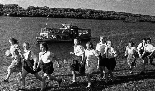 Các em học sinh nữ đi bộ ven sông.