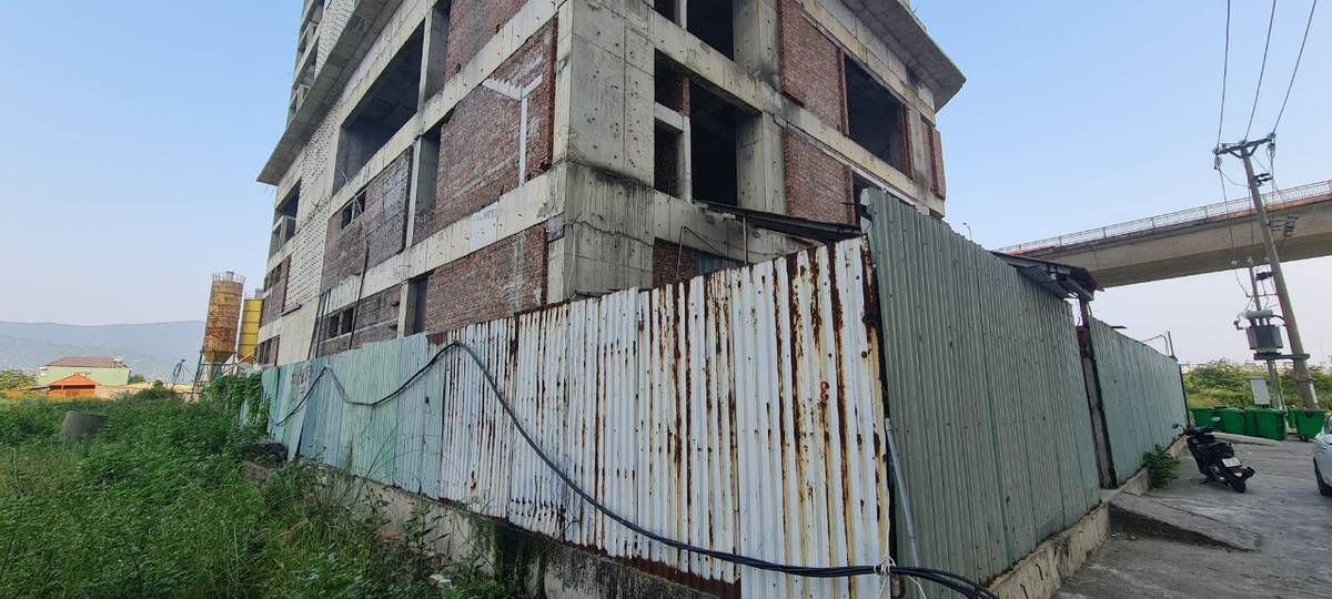 Cỏ dại bao quanh hàng rào tôn đã đổi màu.