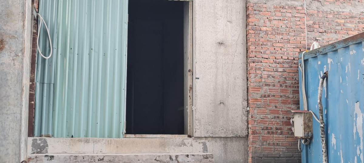 Cửa tạm bằng tôn cũng chỉ còn một nửa.