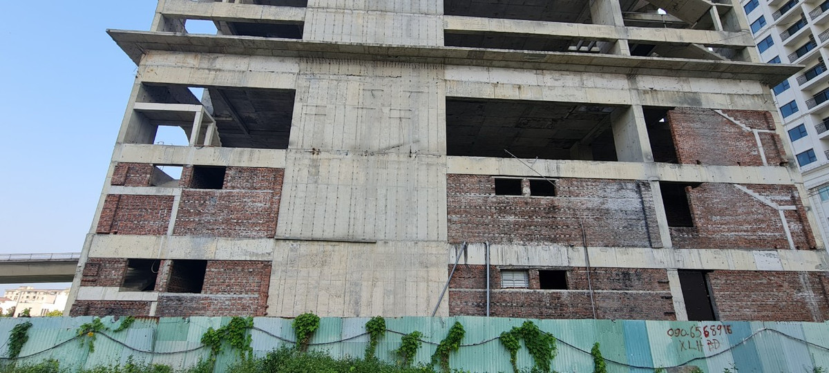 Công trình mới được xây thô thì tạm dừng trong một thời gian dài, cỏ dại đã bò lên cả mét.