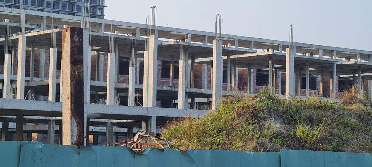 hiều tòa nhà đang xây dựng dang dở thì tạm dừng trong thời gian dài, sắt thép đã hoen gỉ.