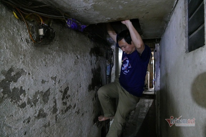 Căn nhà ông Xuân đang ở, thực chất là gác xép nhỏ, có chiều cao 1,17m, rộng 2m và dài 3m. Bố mẹ ông Xuân sinh được 7 người con. Căn nhà nguyên bản rộng hơn 10m2, ngày nhỏ, gia đình 9 người chen chúc thế nào cũng xong, nhưng khi con cái trưởng thành, căn nhà trở nên tù túng. Sau này, căn nhà được chia cho các con. Ông Xuân ở căn gác xép, nằm trên lối đi lại của ngõ. Hiện tại, các anh chị em đã đi nơi khác sinh sống, chỉ còn ông Xuân kinh tế khó khăn nên bám trụ lại. Ngày ngày ông chạy xe ôm, kiếm đồng rau, đồng cháo. (Ảnh Vietnamnet)