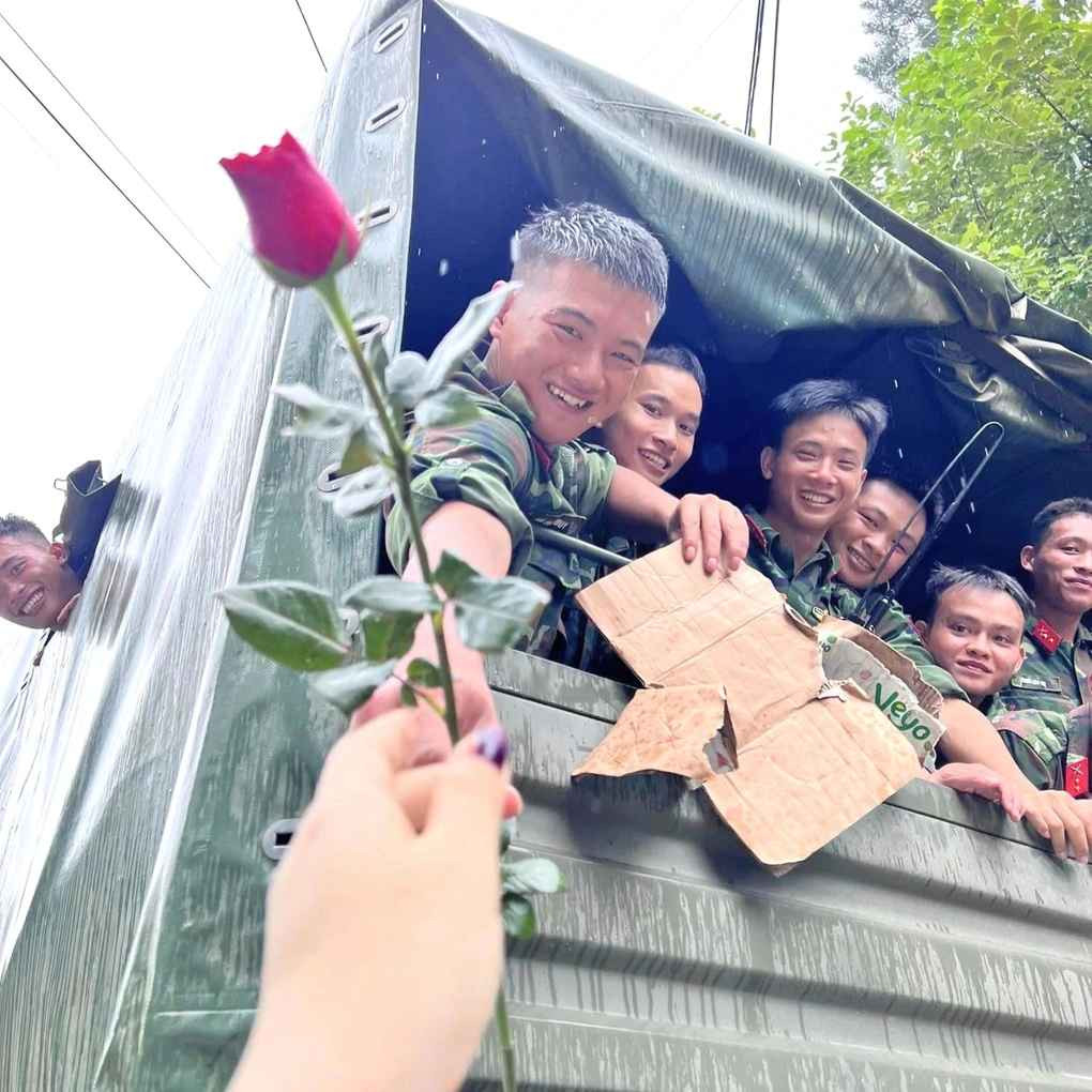 Hình ảnh ghi lại khoảnh khắc người dân tập trung hai bên tuyến đường TP Yên Bái, mang theo cờ, hoa vẫy chào, cảm ơn các anh bộ đội đã giúp đỡ bà con dọn dẹp, khắc phục hậu quả sau mưa lũ.