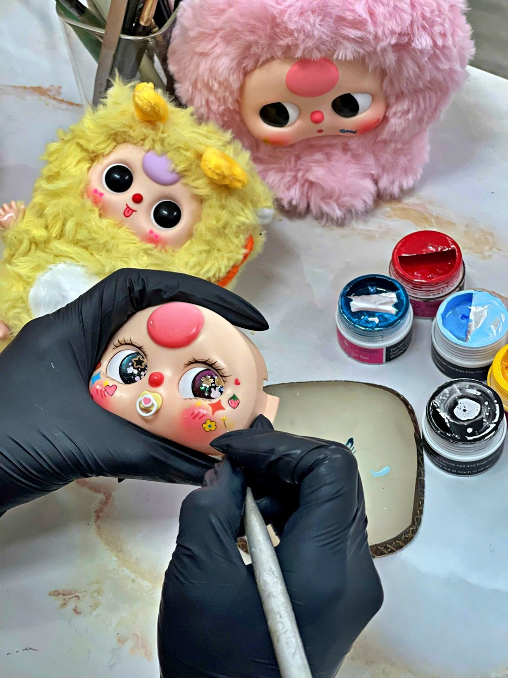 Cận cảnh một búp bê Baby Three được vẽ mặt.