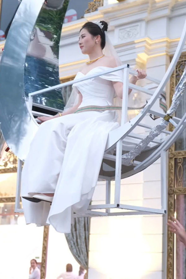 Sau đó, chiếc cần cẩu từ từ di chuyển nhân vật chính về phía sân khấu đám cưới rồi hạ thấp xuống.