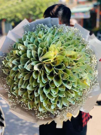 Được biết, thị trường hoa tươi dịp 8/3 năm nay còn chào đón sự phát triển mạnh mẽ của những bó hoa đính tiền. Thông thường, 1 món sẽ được đính từ vài chục đến hàng trăm tờ tiền polymer, mệnh giá dao động từ 50.000, 100.000, 200.000 đến 500.000 đồng…