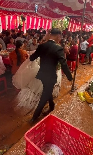 Trong các đoạn clip khác do vị chủ tiệm đăng tải có thể thấy không chỉ khu vực tổ chức đám cưới đầy bùn đất mà đường vào nhà cô dâu cũng trở nên khá khó khăn sau cơn mưa lớn.