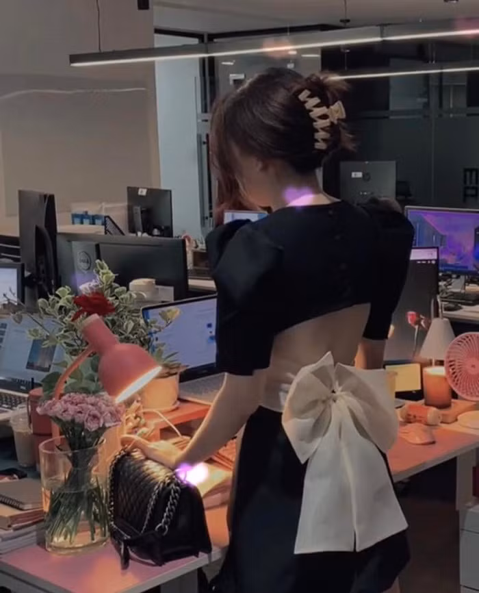 Cụ thể, cô gái xuất hiện tại một văn phòng, phía trước có khá nhiều máy tính và một số đồng nghiệp đang làm việc. Bàn làm việc của cô gái được trang trí rất gọn gàng, đẹp mắt với nhiều món đồ nhỏ xinh màu hồng.