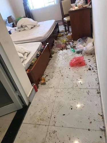 Toàn bộ căn phòng đều rất bừa bộn với nhiều rác thải như chai lọ, cốc mì tôm ăn dở, vỏ hướng dương bị vứt bừa bãi trên bàn, dưới đất và cả trên giường.